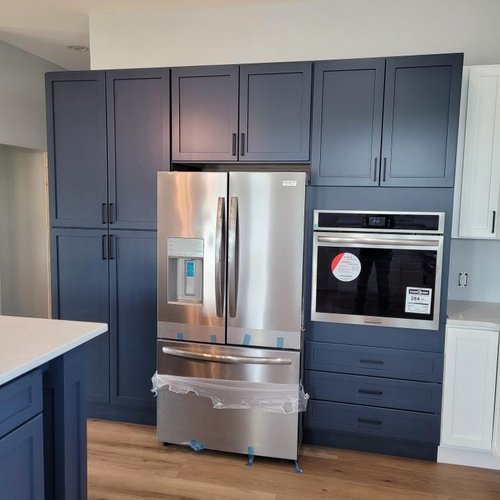 Kitchen with blue cabinets by Xtreme Wholesale